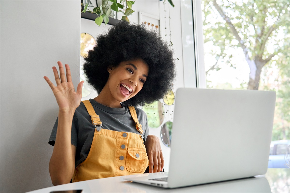 A Tech Navigator waving from a laptop during a live session.