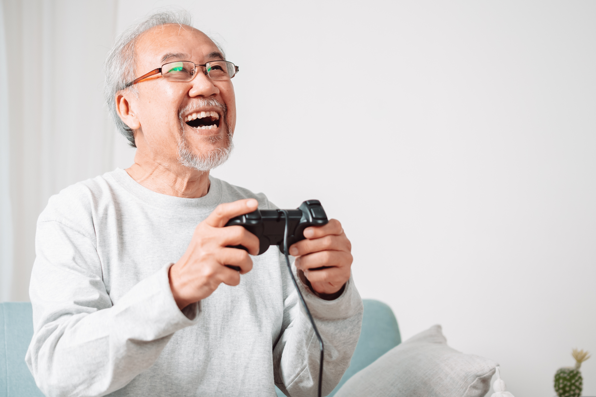 A Seasoned Adult smiling while participating in a Generation Connect gaming activity.